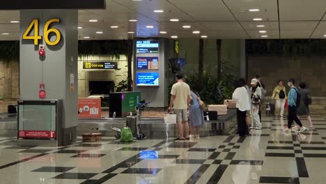 Tourists-Collecting-Their-Checked-in-Luggage-On-Baggage-Carousel-At-Changi-Airport-In-Singapore