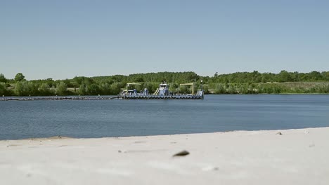 Schöner-Statischer-Blick-Auf-Den-Windigen-See-Mit-Einem-Kleinen-Industrieboot,-Das-Sand-Vom-Grund-Des-Sees-Saugt