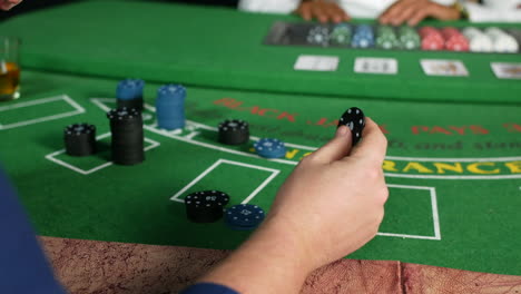 Ein-Mann-Spielt-Mit-Pokerchips-In-Einem-Casino-An-Einem-Blackjack-Tisch