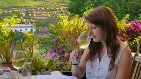 Red-haired-tourist-girl,-tasting-white-wine-in-the-Douro-Valley-which-is-famous-for-wine