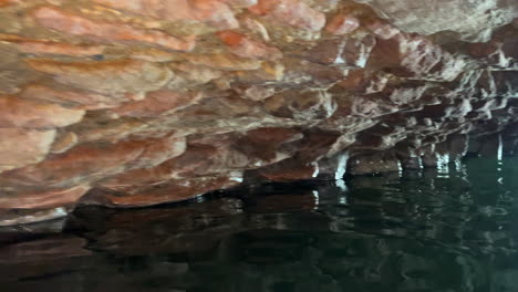 Swimming-through-caves-of-Roman-Baths-of-Casares-Manilva,-natural-spring-healing-sulfur-water-in-Spain,-good-health-benefits,-4K-shot