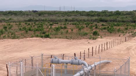 Aerial-view-flying-over-a-gas-pipeline-valve-inside-a-fence-at-a-thermoelectric-power-plant