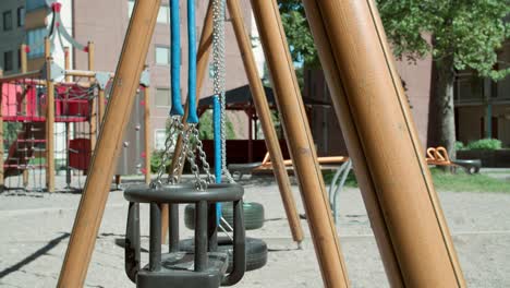 Close-up-of-a-swing-at-an-empty-playground-during-summer