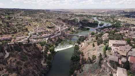 Dynamic-sinking-aerial-of-Puente-de-San-Martin-bridge-in-Toledo,-Spain