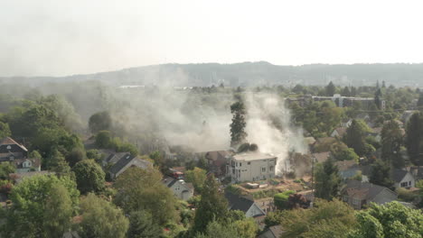 Aerial-shot-through-burning-building-smoke-towards-American-city-centre