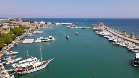 Aerial-orbit-around-marina-Mandraki-in-Rhodes,-Greece-with-approaching-boats