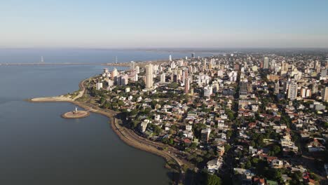 Vista-Aérea-De-La-Ciudad-Costera-De-Posadas-Misiones-Argentina,-Toma-De-Drones-De-Una-Ciudad-Costera-Densamente-Poblada-Cielo-Nublado