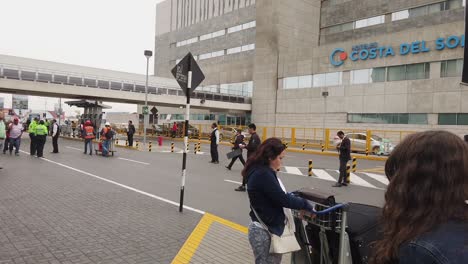 Viajeros-Esperando-En-El-Punto-De-Recogida-Del-Aeropuerto-Internacional-Jorge-Chávez-En-Lima,-Perú-Durante-El-Día.