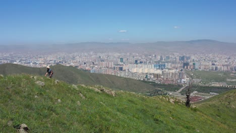 Somebody-strolling-in-the-hills,-with-the-Ulaanbaatar-skyline-in-the-background,-Mongolia's-capital