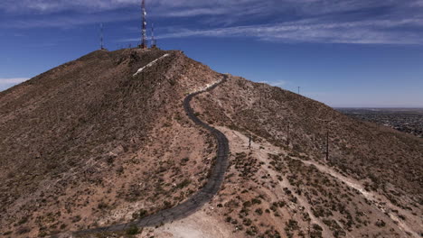 Aerial-dolly-in-towards-radio-towers-on-top-of-mountain-near-El-Paso,-TX