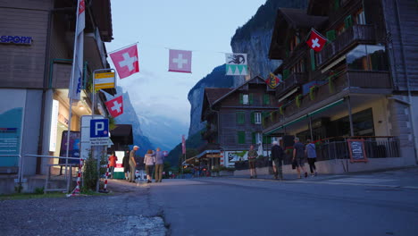 Tourists-enjoy-evening-on-street-of-famous-resort-Lauterbrunnen,-Switzerland