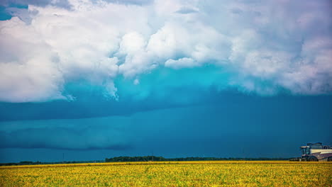 Farmers-working-with-combine-in-fields-while-thunder-storm-forming-above,-time-lapse