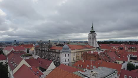 Luftaufnahme-Umkreist-Das-Gerüst-Des-Glockenturms-Der-Kirche-In-Zagreb,-Kroatien,-Umgeben-Von-Rot-Gefliesten-Dächern-Des-Alten-Stadtplatzes