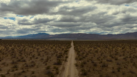 Cloudscape-aerial-hyper-lapse-over-the-Mojave-Desert-with-leading-lines-from-a-dirt-road