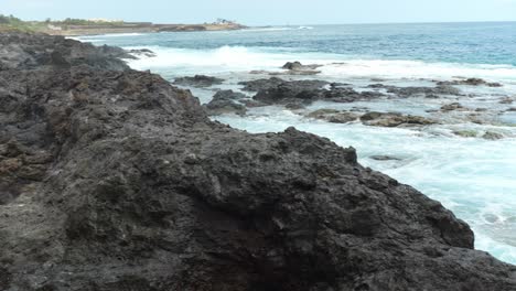 Ocean-waves-washing-rocky-coast-of-Tenerife-island,-pan-right-view
