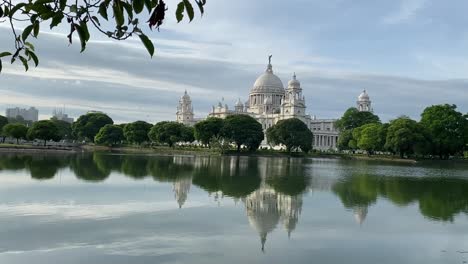 Shot-of-beautiful-Victoria-Memorial-reflection-on-lake-water-in-Kolkata,-West-Bengal,-India-at-daytime