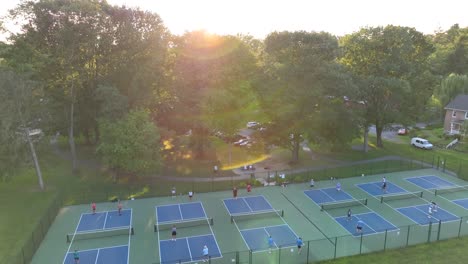Menschen-Spielen-Pickleball-Im-Park-Während-Des-Sonnenuntergangs-Zur-Goldenen-Stunde