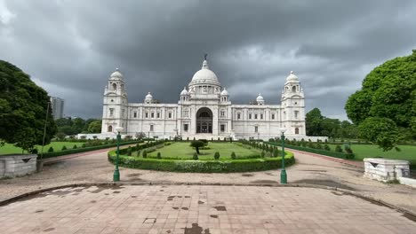 Front-view-of-famous-Victoria-Memorial-surrounded-by-beautiful-garden-in-Kolkata,-West-Bengal,-India-on-a-cloudy-day