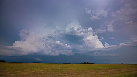 Storm-forming-above-agriculture-fields,-vibrant-dark-clouds,-time-lapse-view