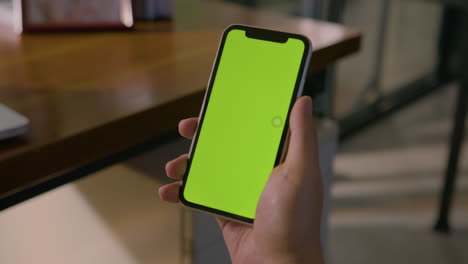 Static-Mid-Shot-Of-A-Man-Holding-Smartphone-With-Chroma-Green-Screen-In-A-Corporate-Environment