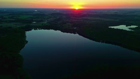 Aerial-Shot-Over-a-Lake-with-the-Sun-on-the-Horizon-During-a-Sunset-in-Latvia