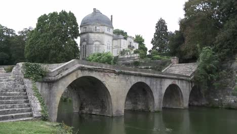 Schloss-Chateauneut-Sur-Loire-Mit-Gewölbter-Steinbrücke-Und-Wasser,-Frankreich,-Loiretal