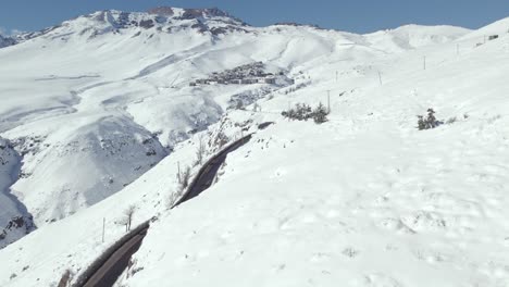 Drohnenaufnahme-Der-Straße-Auf-Dem-Weg-Zum-Exklusiven-Skigebiet-La-Parva-Voller-Schnee-An-Einem-Sonnigen-Tag-In-Den-Anden,-Chile