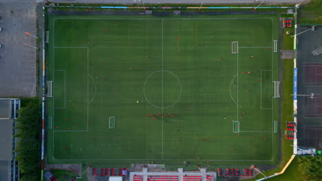 Top-shot-of-a-soccer-field-with-people-practicing,-field-divided-into-smaller-sections