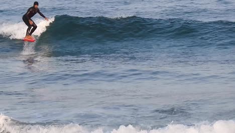 Young-man-riding-a-foil-surf,-breaking-the-ocean-waves