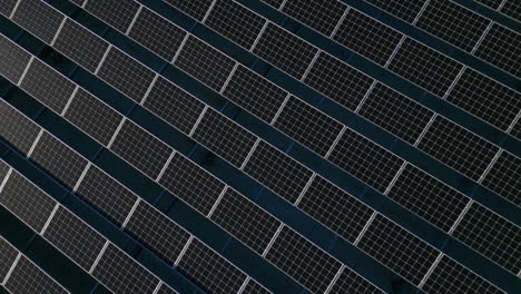 Top-shot-of-solar-panels,-moving-up-to-reveal-more