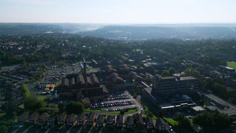 Luftaufnahmen-Zeigen-Staincliff,-Großbritannien,-Mit-Industrieanlagen,-Belebten-Straßen,-Dem-Dewsbury-General-Hospital-Und-Der-Landschaft-Von-Yorkshire-An-Einem-Sommermorgen