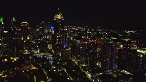 Nachtaufnahme,-Die-Von-Den-Lichtern-Und-Wolkenkratzern-Der-Innenstadt-Von-Atlanta,-Georgia,-Wegfliegt