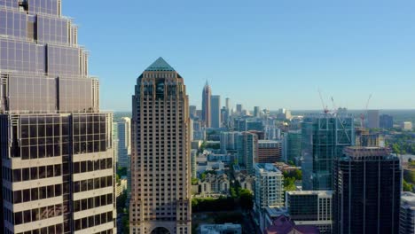 Drone-shot-slowly-passing-a-skyscraper-to-reveal-downtown-Atlanta,-Georgia