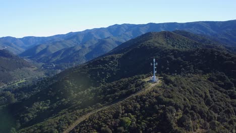 Orbiting-around-a-networking-tower-on-a-hill-with-mountains-in-the-background