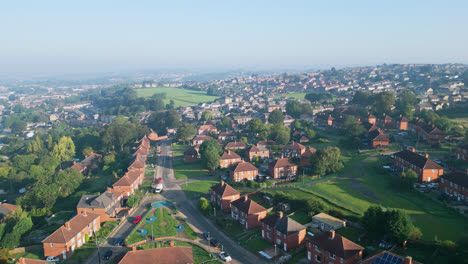 A-drone's-gaze-at-Dewsbury-Moore-Council-estate,-UK,-showcasing-red-brick-housing-and-Yorkshire's-industry-on-a-sunny-day