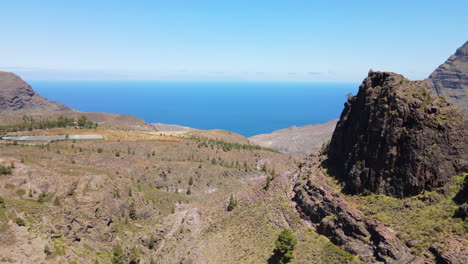 Tamadaba-Natural-Park,-Tirma:-aerial-view-passing-near-large-rock-formations-in-this-natural-park-on-the-island-of-Gran-Canaria-on-a-sunny-day