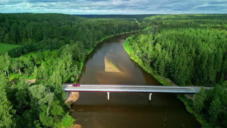 Aerial-View-Of-Vehicle-Parked-Over-Bridge-In-River-Stream-Surrounded-By-Coniferous-Tree-Forest