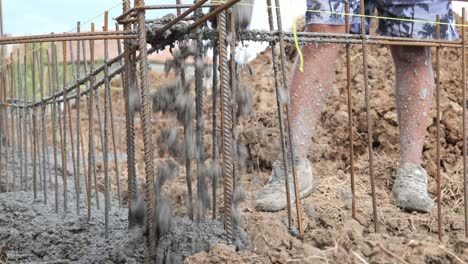 Pouring-concrete-into-rebar-reinforcement-trench-from-delivery-hose