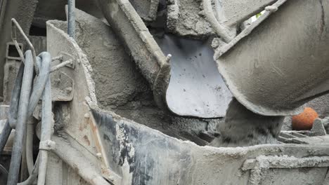 Ready-mix-concrete-transfers-wet-material-to-delivery-truck-chute-close-up