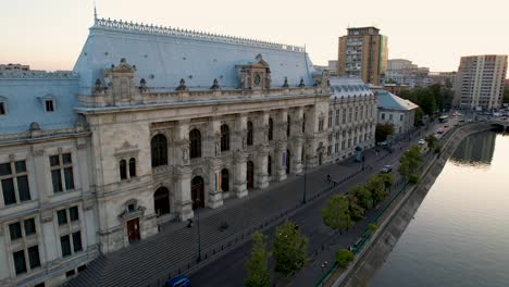 Puesta-De-Sol-Sobre-El-Palacio-De-Justicia-Y-El-Río-Dambovita-En-Bucarest,-Rumania,-Vista-Aérea