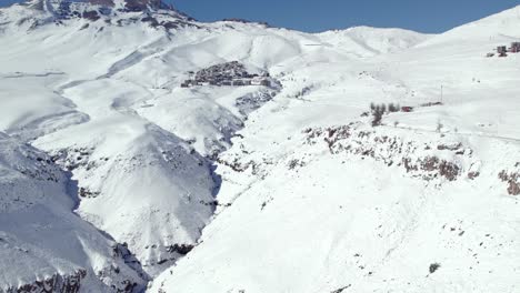 Aerial-establishing-view-of-Exclusive-Ski-Resort-La-Parva-at-Snowy-hillside,-Chile