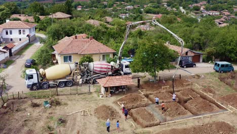 Cement-mixer-boom-pump-pours-ready-mix-concrete-for-footings-drone-view