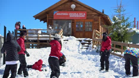 People-in-winter-clothes-playing-with-the-snow-at-Farellones-Snow-resort,-Chile