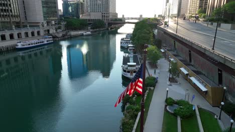 American-flag-waving-in-front-of-Chicago-River-head-in-downtown-Chicago,-Illinois