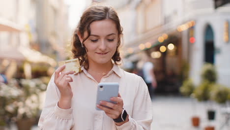 Junge-Frau-Benutzt-Smartphone-Mit-Kreditkarte,-Während-Sie-Geld-überweist,-Kauft-Online-Ein