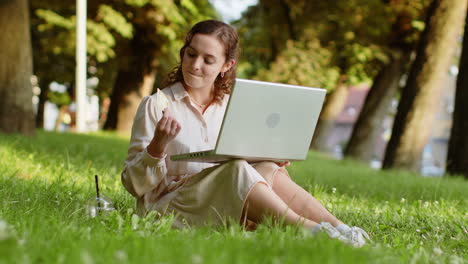 Woman-using-credit-bank-card-and-laptop,-transferring-money,-purchases-online-shopping-in-city-park