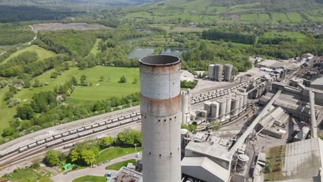 Aerial-drone-flight-around-the-main-chimney-stack-of-Breedon-Hope-Cement-Works-with-a-panoramic-view-of-the-surrounding-Peak-District