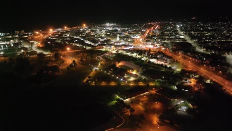 Beautiful-night-time-cityscape-of-Timaru-coastal-town,-illuminated-streets-and-Caroline-Bay,-New-Zealand-aerial