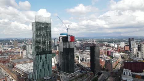 Aerial-drone-flight-of-a-new-skyscraper-building-under-construction-next-to-the-Beetham-Tower-with-a-slow-revealing-view-of-Manchester-City-Centre