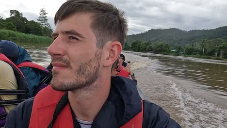Mann-Auf-Schnellboot,-Das-Mit-Anderen-Touristen-Den-Kinabatangan-Fluss-Entlang-Segelt